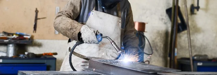 Person schweißt Metall mit Schweißgerät